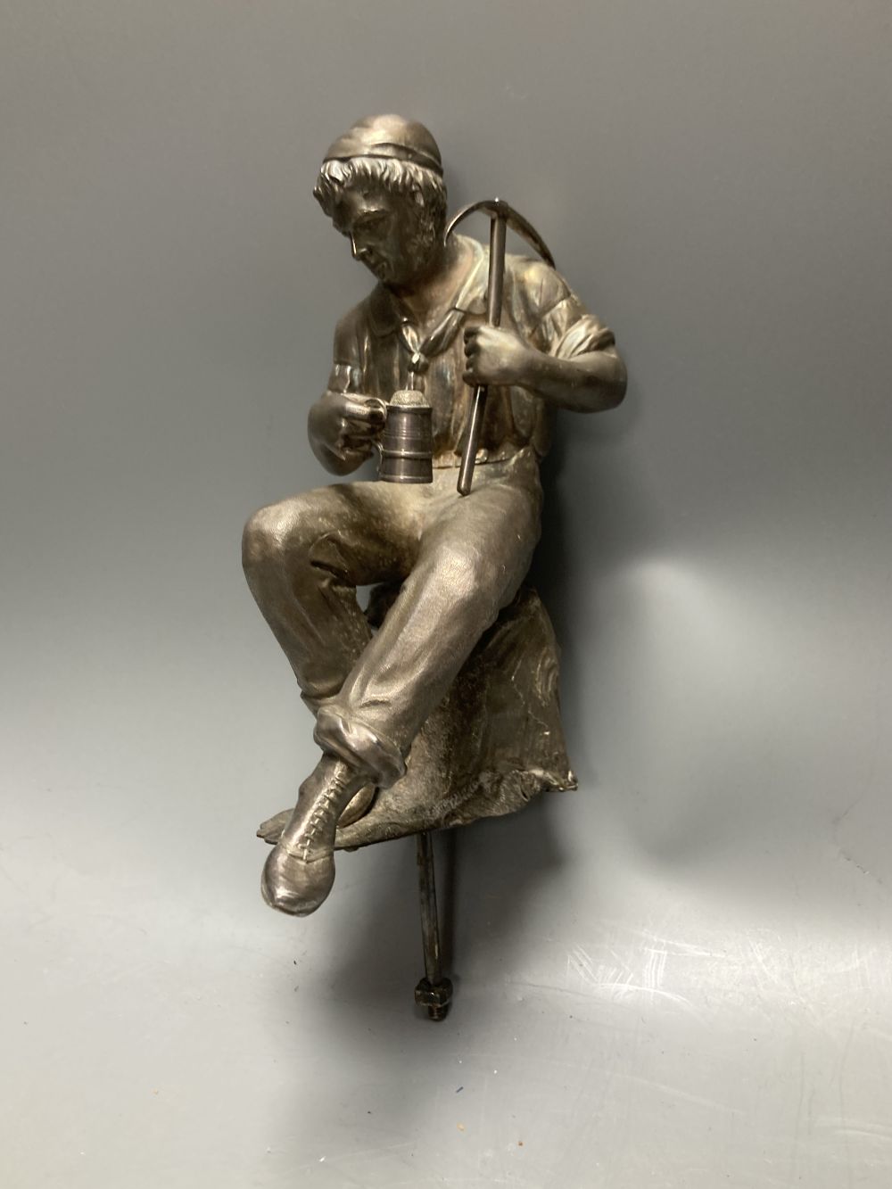 A Victorian silver plated model of a seated tin miner